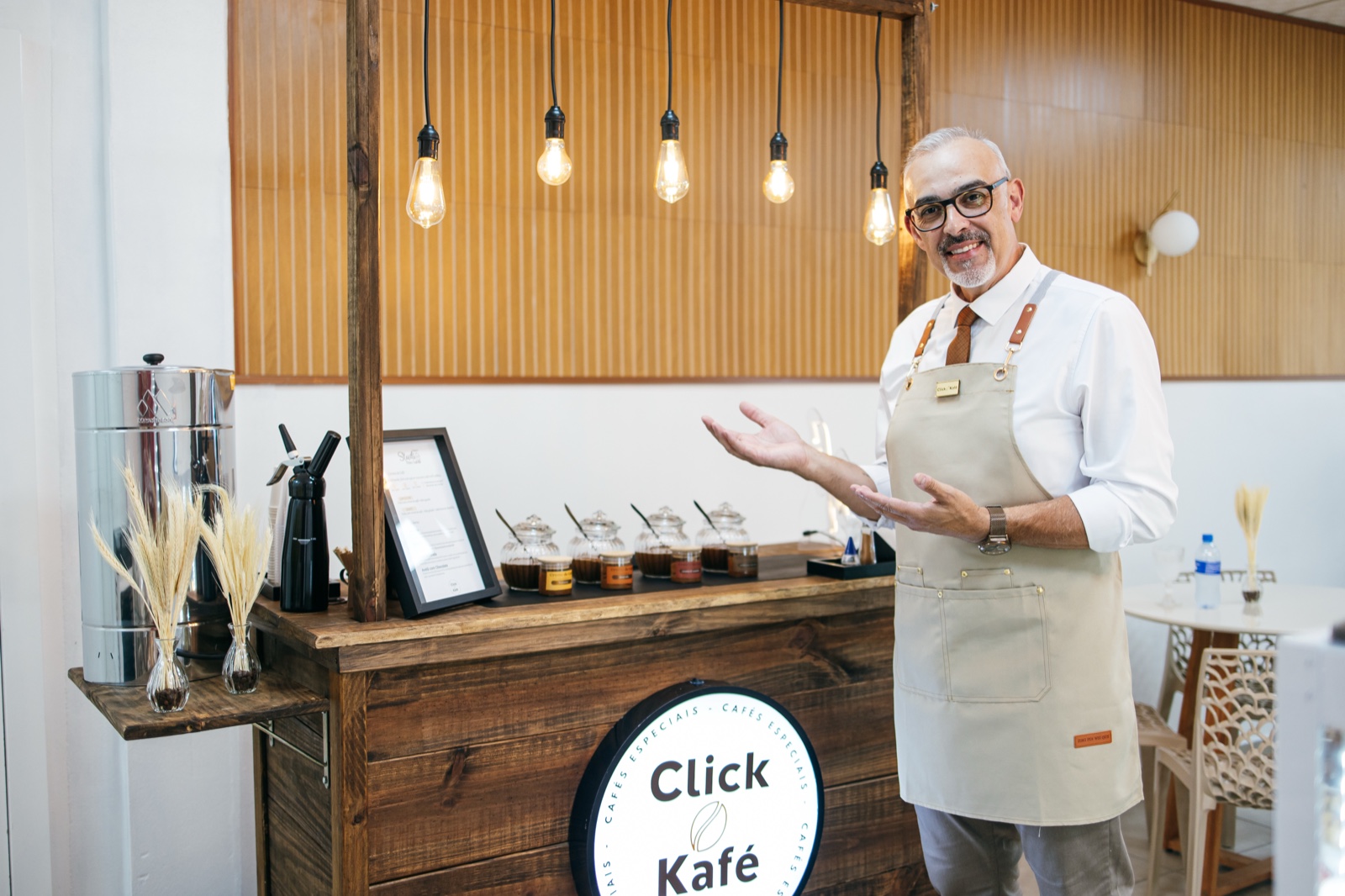 Adriano da Click Kafé apresentando os jarros de cremes especiais na estação Raízes