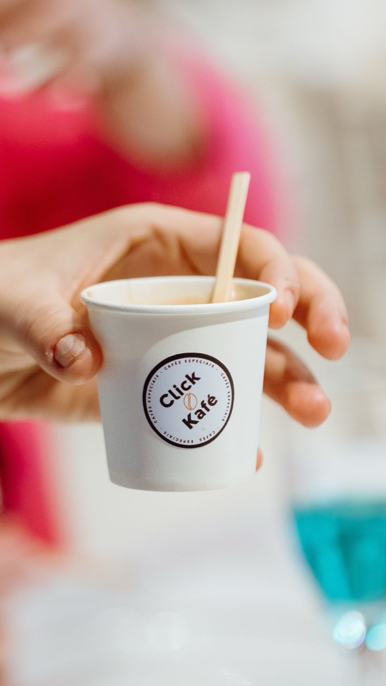 Copo personalizado Click Kafé sendo entregue